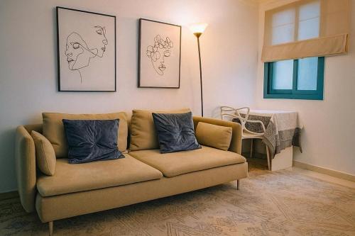 un canapé dans un salon avec des tableaux accrochés au mur dans l'établissement Sharjah corniche private room for women only, à Charjah