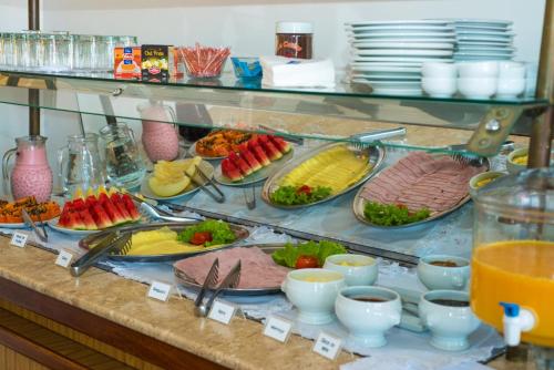 a buffet with many plates of food on a counter at Hotel Obino in São Gabriel