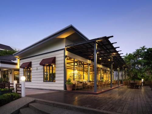 a building with a lot of windows and tables at Novotel Rayong Rim Pae Resort in Klaeng