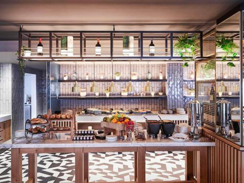 a kitchen with a counter with food on it at Novotel Birmingham Airport Terminal Building - NEC in Bickenhill