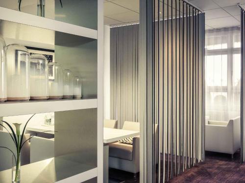 een kamer met een tafel, stoelen en een raam bij Mercure Paris Massy Gare TGV in Massy