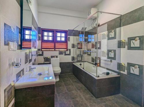 een badkamer met een bad, een wastafel en een toilet bij Sun Set Forest Villa in Kandy