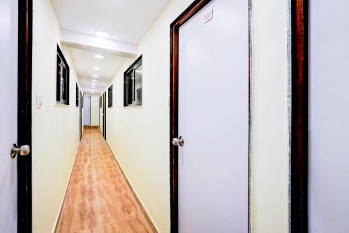 a hallway with white doors and a wooden floor at Hotel O Metro Galaxy inn in Mumbai