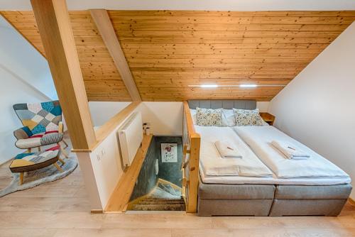 een kleine slaapkamer met een bed en een stoel bij Valašský dvůr in Velké Karlovice