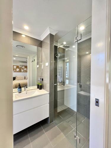 a white bathroom with a sink and a shower at Lakeview at Berringer in Manyana
