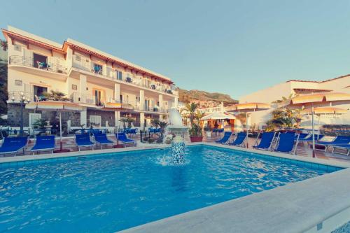una piscina en un hotel con sillas y una fuente en Hotel Riva del Sole en Isquia