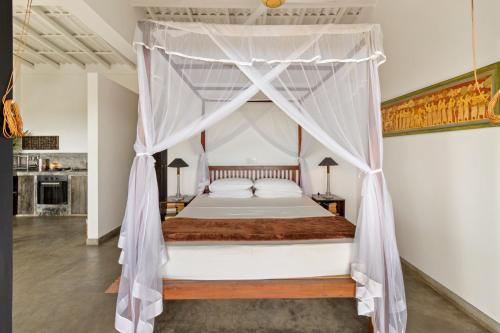 乌纳瓦图纳劳拉之家酒店的一间卧室，里面有一张带帷幔的床