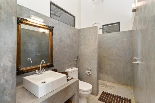 乌纳瓦图纳劳拉之家酒店的浴室里有洗手池、马桶和镜子。