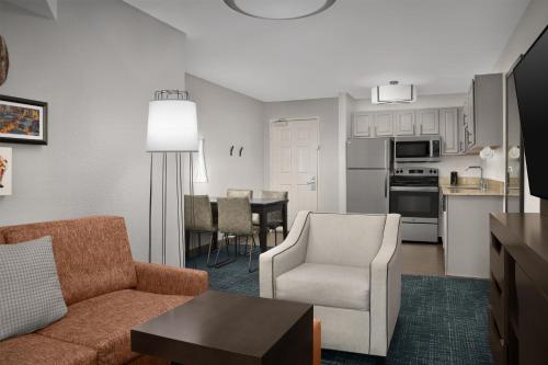 a living room with a couch and chairs and a kitchen at Hampton Inn & Suites Denver Tech Center in Centennial