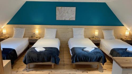 drie bedden in een kamer met blauwe muren bij L'estive gîte 4 étoiles in Nasbinals