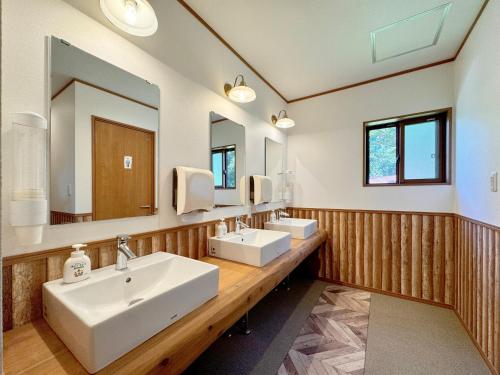 a bathroom with two sinks and two mirrors at Lodge ぷるーく in Myoko