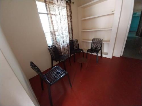 een kamer met stoelen, een tafel en een raam bij Allô Gite in Pondicherry