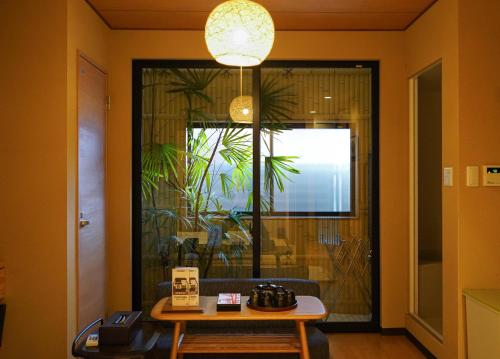 a room with a table and a large window at Shirakabanoyado - SHIOKUSA, 白樺の宿 - 塩草 in Osaka
