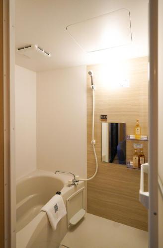 a bathroom with a bath tub with a light at Shirakabanoyado - SHIOKUSA, 白樺の宿 - 塩草 in Osaka