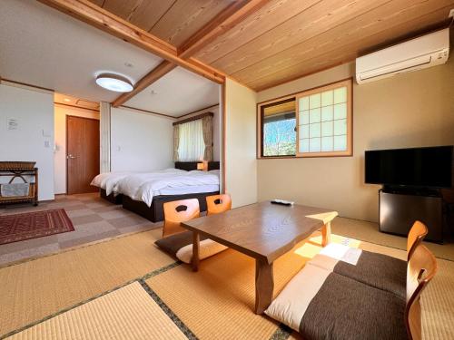 a bedroom with a bed and a table in a room at Lodge ぷるーく in Myoko