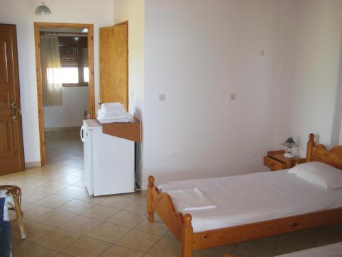 a bedroom with a bed and a white refrigerator at guest house kalamaki beach preveza in Rizá