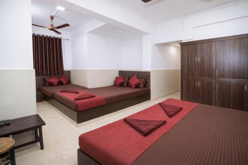 een kamer met 2 bedden en rode kussens bij Hotel Golden Heritage in Merces