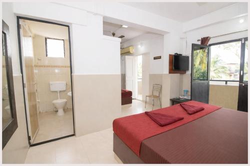 een slaapkamer met een rood bed en een badkamer bij Hotel Golden Heritage in Merces