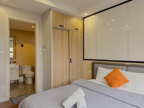 a bedroom with a bed and a bathroom with a toilet at QMP - Vinhomes D'Capitale Tran Duy Hung in Hanoi