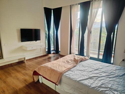 ein Schlafzimmer mit einem Bett und einem Fernseher und Fenstern in der Unterkunft Green Courtyard Luxury Villa in Badlapur