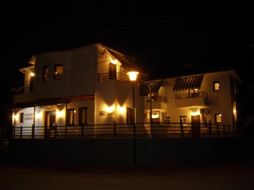 a white building with lights in the dark at Aurora in Platanias