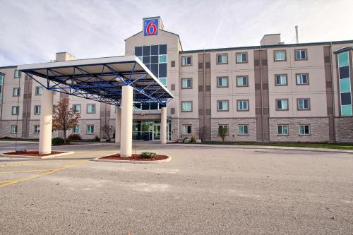 a large building with a parking lot in front of it at Motel 6-London, ON - Ontario in London
