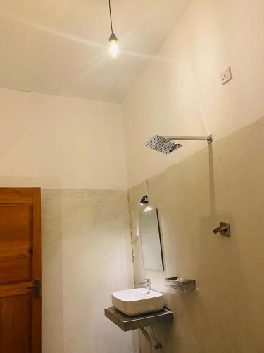 a bathroom with a sink and a mirror at Emerald retreat in Ahangama