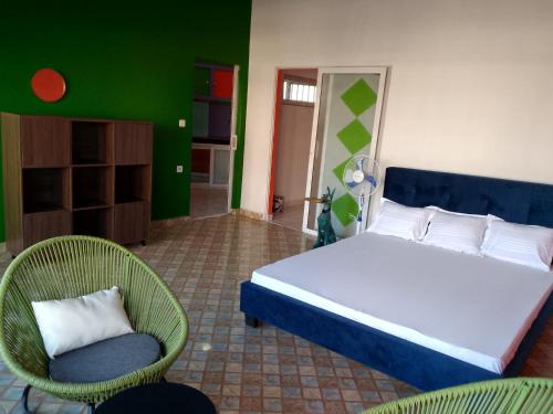 een slaapkamer met een groot bed en twee stoelen bij Sakinu Appartement in Mahajanga