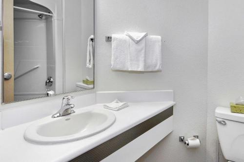 a white bathroom with a sink and a mirror at Motel 6-Peterborough, ON in Peterborough