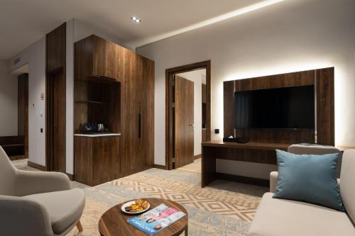 a living room with a couch and a tv at Qashqadaryo Hotel Olympic Village in Tashkent