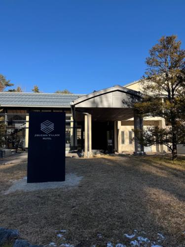 a building with a sign in front of it at Jibuzaka Village Hotel in Achi