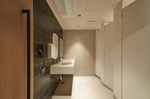 a bathroom with a sink and a mirror at Monrêve Cabins 몽헤브캐빈즈 in Seoul