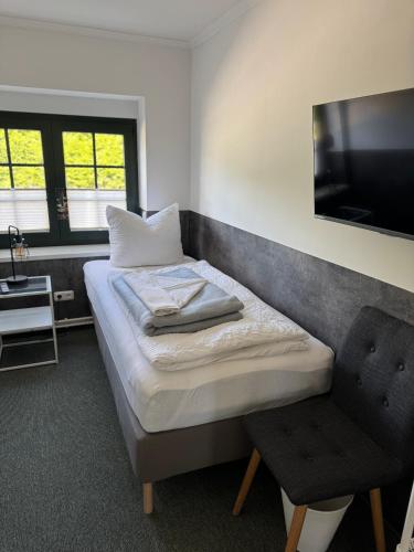 a bedroom with a bed and a chair and a television at Ferienhaus 26 Bernd mit 10-Schlafzimmer in Greifswald in Heilgeisthof