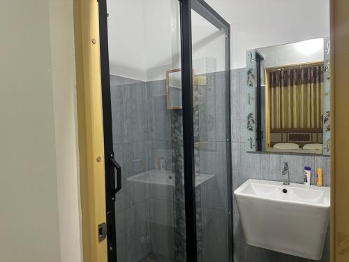 a bathroom with a shower and a sink and a mirror at Naturus Villa Thalpitiya in Panadura