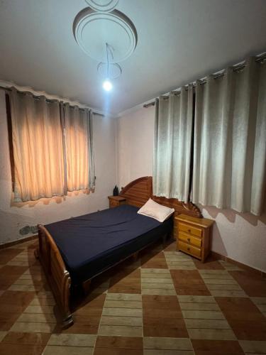 een slaapkamer met een bed en een kroonluchter bij espace familiale in Azrou