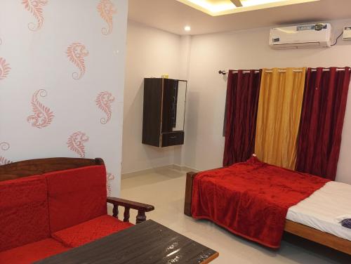a room with a bed and a couch and a chair at Rooms & Food Sri Ranga in Belūr