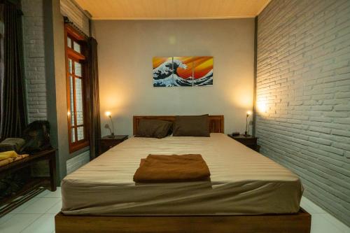 een groot bed in een kamer met een bakstenen muur bij G Beach Hotel in Grajagan