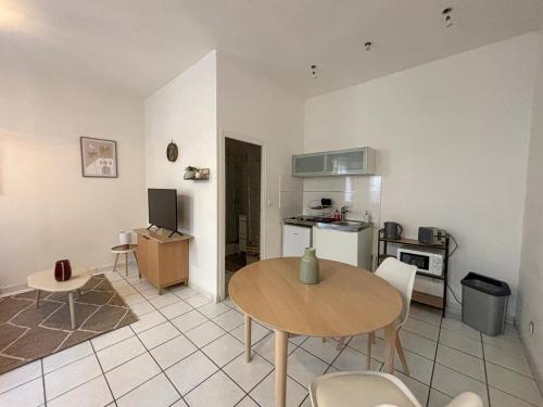 een woonkamer met een tafel en een keuken bij Le Studio 3, Calme & Cosy à 2 Pas de Stanislas in Nancy