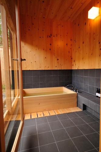 a bath tub in a bathroom with wooden walls at 五島列島おぢか島 古民家ステイ Ojika Island Kominka Stay in Ojika