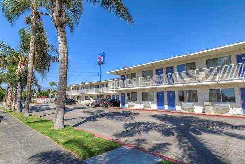 a hotel with palm trees in front of a street at Motel 6-San Bernardino, CA - South in San Bernardino