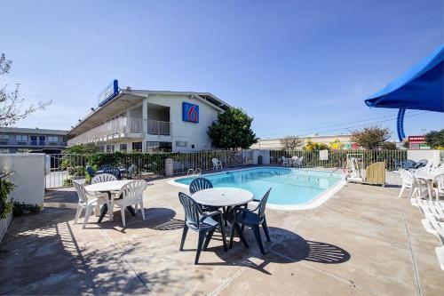 a patio with tables and chairs next to a pool at Motel 6-Laredo, TX - South in Laredo