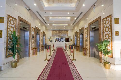 a hallway with a red carpet in a building at Al Khulfaa Al Masy - فندق الخلفاء الماسي in Makkah