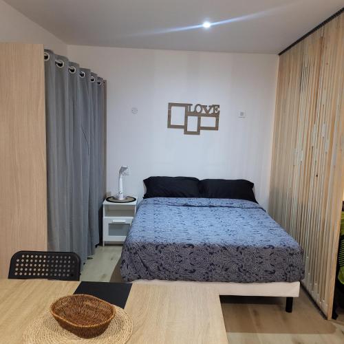 ein Schlafzimmer mit einem Bett und einem Tisch darin in der Unterkunft Riverside in Montereau-faut-Yonne