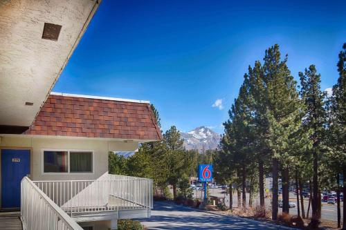 a building next to a road with a mountain at Motel 6-Mammoth Lakes, CA in Mammoth Lakes