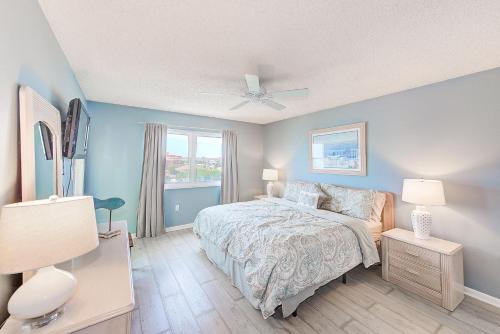 una camera da letto blu con un letto e una finestra di Beachfront Condo Sleeps 10 Heated Pool - 307 a St Pete Beach