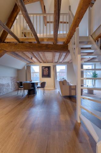 a large living room with wooden ceilings and a staircase at House of De Swaen Apartments in Breda