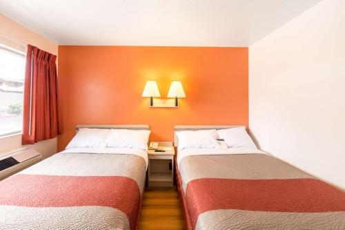 two beds in a room with orange walls at Motel 6-Klamath Falls, OR in Klamath Falls