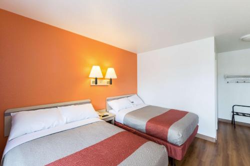 two beds in a room with orange walls at Motel 6-Klamath Falls, OR in Klamath Falls