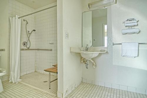 a white bathroom with a sink and a shower at Skyline Inn in Conway