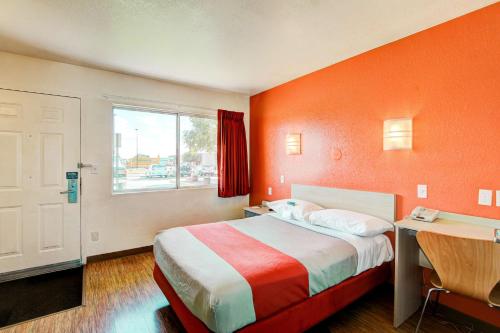 a hotel room with a bed and a desk and a window at Motel 6-Denver, CO - Airport in Denver